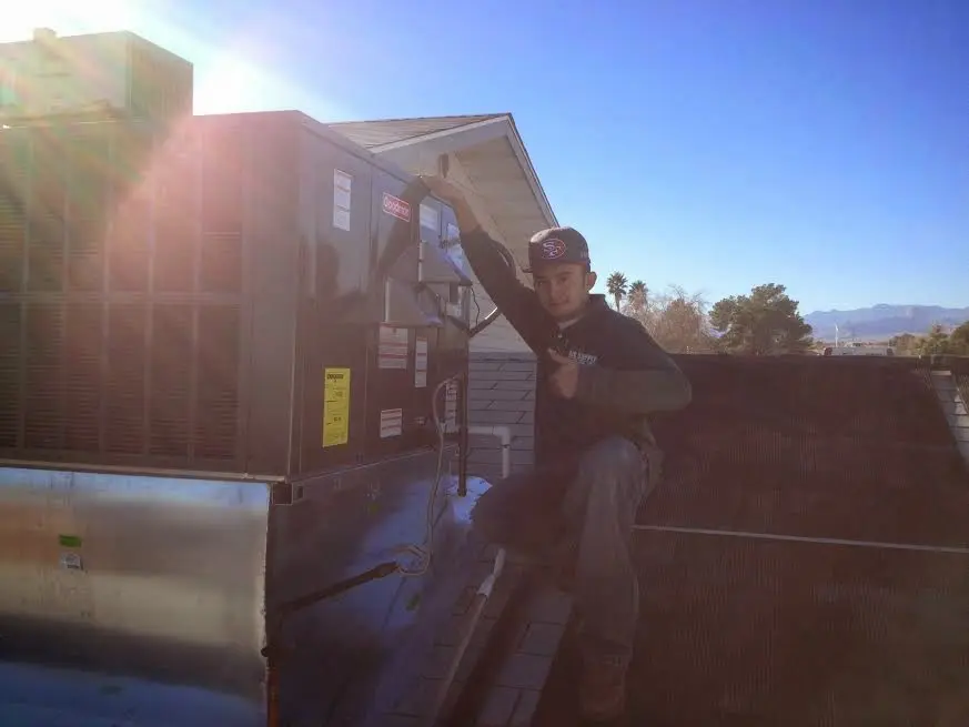 HVAC technician performing AC Tune-Up on a rooftop unit in Pleasant Run